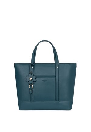 Turchese leren tote bag met dubbele handvatten, voorzak en een bloemvormige leren sleutelhanger als decoratie.