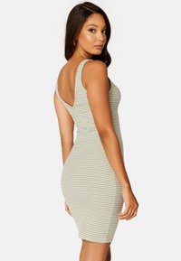Abito bodycon a righe in verde chiaro e bianco, caratterizzato da uno scollo a pescatore, design senza maniche e una silhouette aderente. Tessuto morbido e elasticizzato.