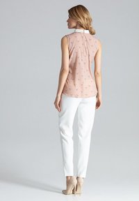 Mouwloze roze blouse met een witte kraag, voorzien van een subtiele vogelpatroon, gecombineerd met witte op maat gemaakte broek en nude hoge hakken.