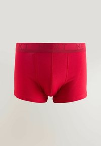 Red cotton boxer shorts with a smooth texture, featuring a wide waistband embossed with the brand name "NEXT" in a contrasting darker red.