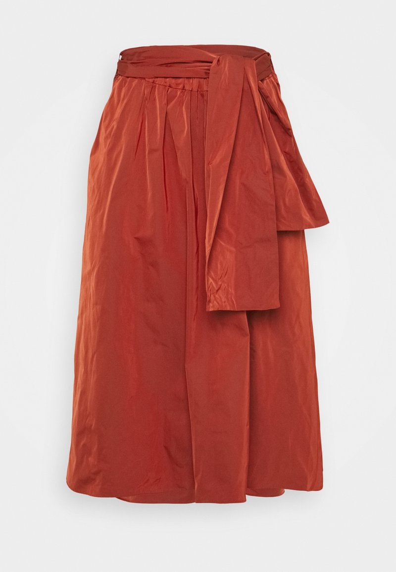 Jupe midi couleur rouille avec une taille froncée et une large ceinture en tissu nouée sur le côté.