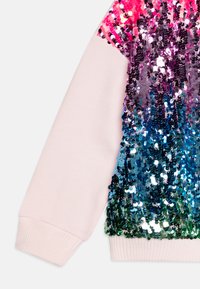 Džemper sa šljokicama, ružičasti gornji deo, višebojne šljokice koje se slijevaju od ljubičaste do plave i zelene, završava sa rebrastim manžetama.