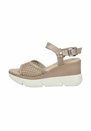 Sandalo beige con zeppa e suola spessa bianca, cinturino in rete sopra le dita e cinturino regolabile alla caviglia con fibbia argento.