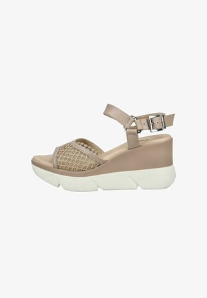 Beige kilehælsandal med hvid tyk sål, netrem over tæerne og justerbar ankelrem med sølvspænde.