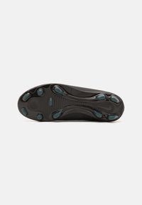 Semelle de chaussure de sport noire avec une surface texturée, dotée de plusieurs éléments de soutien en turquoise et de motifs de traction distincts.