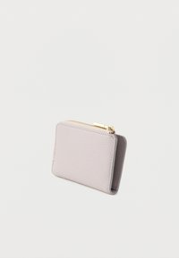 Vaaleanpunainen nahkainen lompakko, jossa on teksturoitu pinta, suorakaiteen muotoinen ja kultainen vetoketjusuljin. Kompakti ja minimalistinen muotoilu.