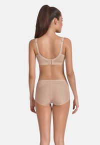 Beige lingerie set featuring a seamless bra with textured bands and adjustable straps, paired with matching textured boyshorts.