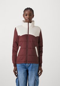 Bordeaux kleuren pufferjack met een crème kleurige kraag en borstpaneel, voorzien van zijzakken en een ritssluiting. Textuurstof met horizontale stiksels.