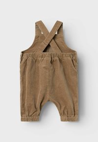 Doposcuola in corduroy color marrone chiaro con bretelle incrociate, vita elastica e polsini arricciati. Attrezzato con due tasche laterali.