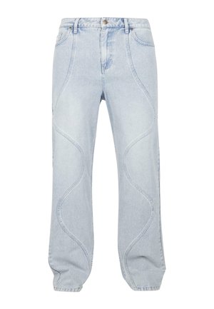Jeans de mezclilla azul claro con patrones de costura curvados, cierre de botón y un ajuste relajado. La tela tiene una textura suave con un ligero desvanecimiento.