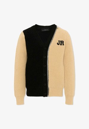 Beige en zwarte geribbelde gebreide cardigan met knopen aan de voorkant aan de zwarte zijde en rits aan de beige zijde, met zwarte "JR" letters op de borst.