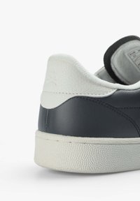 Sneakerabsatz aus navy Leder mit einem strukturierten weißen Lederakzent, ausgestattet mit einer Gummisohle und einem geprägten Logo auf der Rückseite.