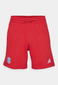 Shorts de sport rouges en tissu doux et respirant. Dotés d'une taille élastique avec cordon de serrage, du logo FC Bayern München et du branding Adidas.