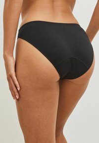 Zwarte katoen onderbroeken met een hoge taille, een gladde textuur en een subtiele stiksel langs de tailleband en beenopeningen.