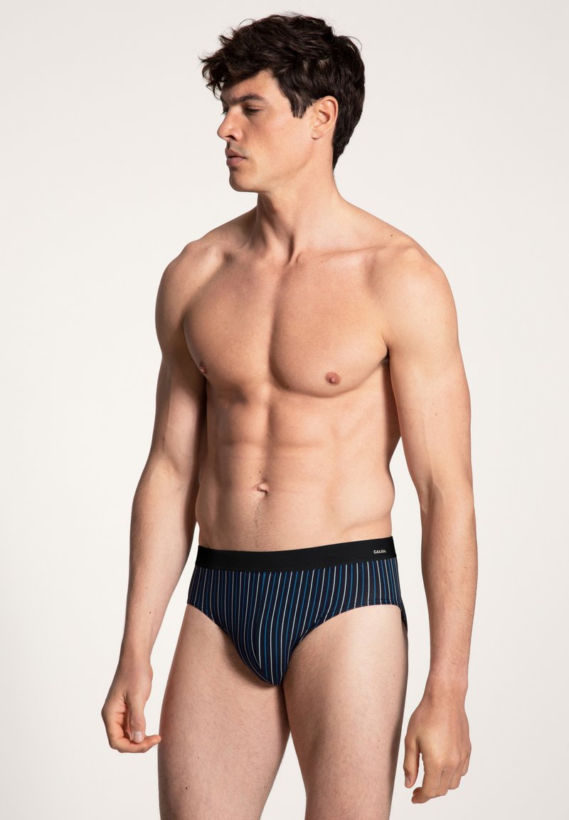 Slips da uomo blu navy con righe bianche verticali, realizzati in un materiale morbido, con un elastico in vita nero.