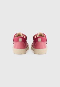 Sneakers alte rosa con una toma superiore in tessuto testurizzato e dettagli in pelle liscia, dotati di una suola in gomma beige e chiusura con fascia in tessuto.