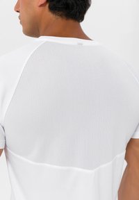 Hvid T-shirt med et åndbart mesh-panel bagpå, korte ærmer og en glat tekstur. Rent design med minimale detaljer.