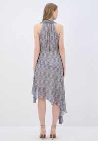 Robe à halter en tissu léger, avec un motif à carreaux bleu et blanc, un ourlet asymétrique et un dos plongeant.