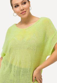 Helles gelbgrünes, oversized Strickoberteil mit lockerer, strukturiertem Design und weitem Halsausschnitt. Verfügt über kurze Ärmel und eine weiche, luftige Erscheinung.