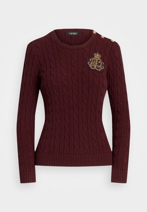 Pull en maille torsadée bordeaux avec manches longues, encolure ronde, boutons dorés sur les épaules et écusson brodé sur la poitrine à gauche.