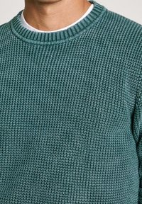 Türkiser Strickpullover mit einem gerippten Rundhalsausschnitt. Besitzt einen strukturierten Stoff und eine taillierte Silhouette. Keine zusätzlichen Muster oder Akzente.