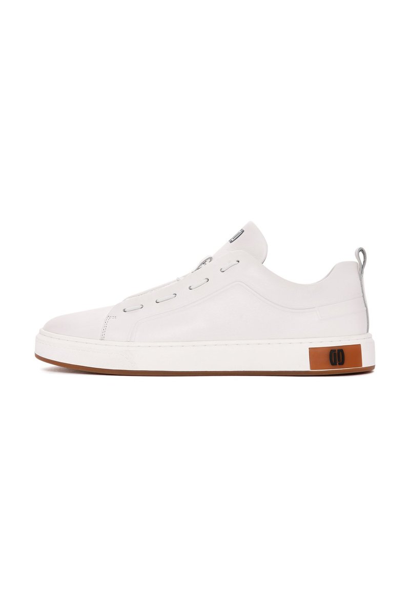 Zapatilla blanca de cuero con perfil bajo, punta redonda y suela de goma. Presenta ojales en tono plateado y un acento marrón con detalle del logo.