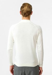 Witte, lange mouwen trui voor heren met een slim fit, geribbelde manchetten en zoom, een gladde textuur en raglanmouwen.