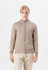 Bežna zip-up pulover s visokim ovratnikom, dolgimi rokavi in rebrastimi manšetami, izdelan iz mehkega materiala, z enostavno teksturo in minimalnim dizajnom.