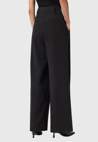 Zwarte brede benen broek met een geribde textuur, hoge taille, zijzakken en een gladde afwerking. Heeft een strikte uitstraling en een nette pasvorm.