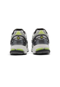 Πίσω όψη αθλητικών παπουτσιών με πλέγμα στο πάνω μέρος σε γκρι και μαύρο, με φωτεινές πράσινες λεπτομέρειες και μαλακή σόλα για άνεση.