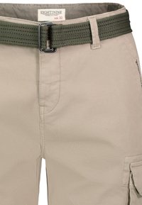 Beige Cargo-Shorts mit einem grünen gewebten Gürtel, die mit Nähdetails und Seitentaschen ausgestattet sind. Das Größenetikett trägt die Aufschrift "EIGHT2NINE Größe 32".