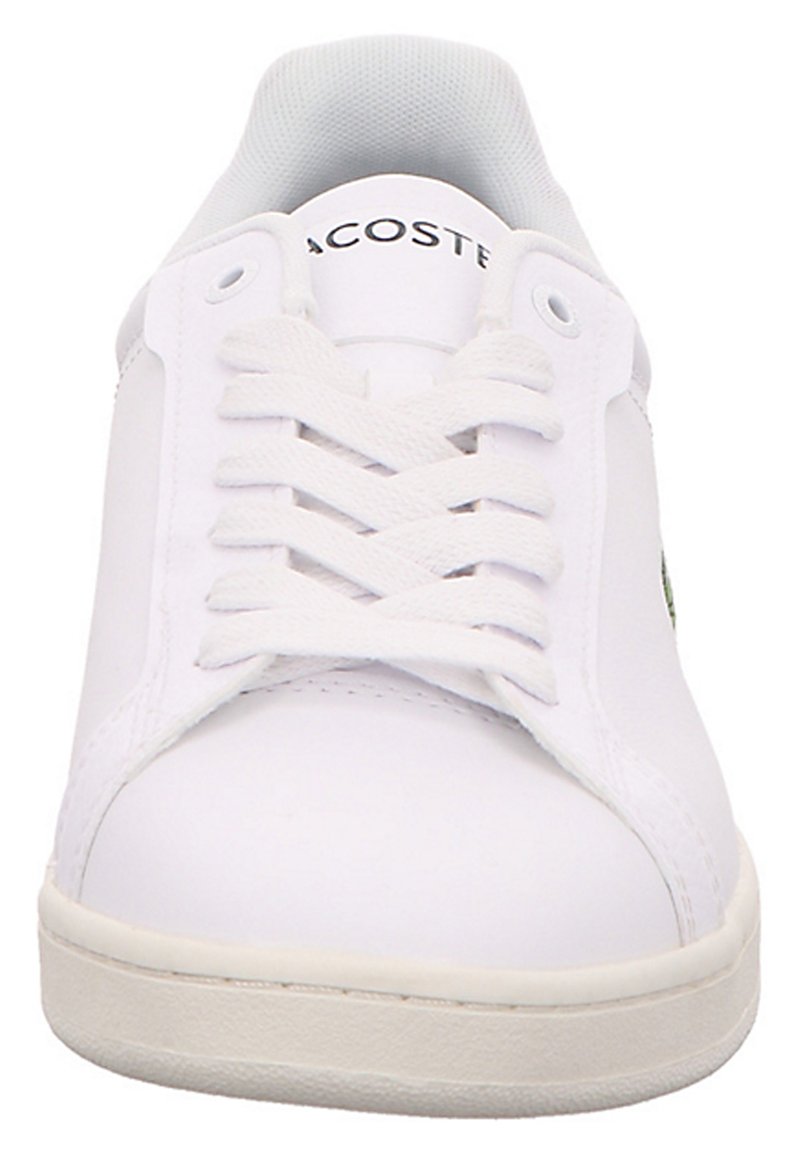 Białe sneakersy na sznurówki z gładką syntetyczną cholewą. Posiadają teksturowany język oraz małe zielone logo po boku. Gumowa podeszwa.