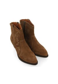 Botas de tobillo de ante marrón con punta afilada, cremalleras laterales y un patrón de costura decorativo en el exterior. Tacón plano y interior suave.