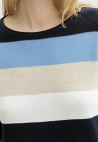 Stickad tröja med horisontella ränder i ljusblått, krämfärgat, vitt och marinblått. Rund halsringning och strukturerad stickad tyg.