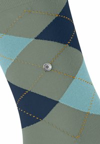 Skarpetki w wzór argyle w odcieniach zieleni, niebieskiego i granatu z pomarańczowymi szwami. Posiadają srebrny detal logo w pobliżu środka. Miękka tekstura materiału.