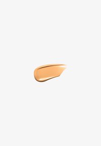 Trait lisse de fond de teint liquide beige avec une finition brillante sur un fond gris clair.
