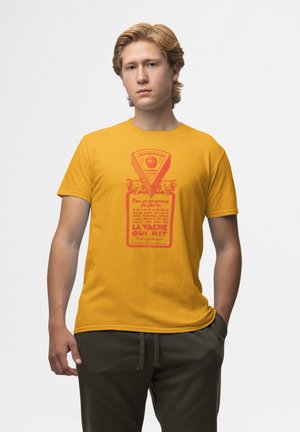 Žluté bavlněné tričko s červeným grafickým designem, který připomíná obaly na sýr, se středovým textem a ilustracemi krav.