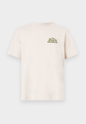 T-shirt in cotone crema con maniche corte. Presenta un testo del logo verde "The Doors ELEMENT X TIMBER!" nella zona sinistra del petto.