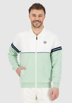 Lichte zip-up jas met een mintgroene body, witte bovensectie en marineblauwe strepen. Heeft een staande kraag en voorzakken.