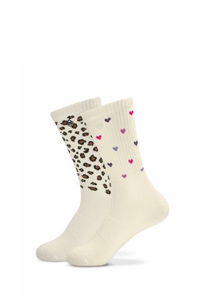 Deux paires de chaussettes hautes couleur crème, l’une avec un imprimé léopard et l’autre avec de petits motifs de cœurs multicolores.