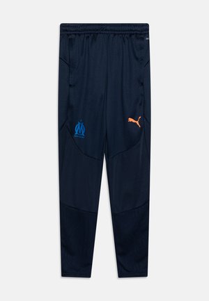 Navy Sporthosen aus atmungsaktivem Material, mit blauem Marseille-Logo und orangefarbenem Puma-Logo, Seitentaschen und einem schmal zulaufenden Bein-Design.