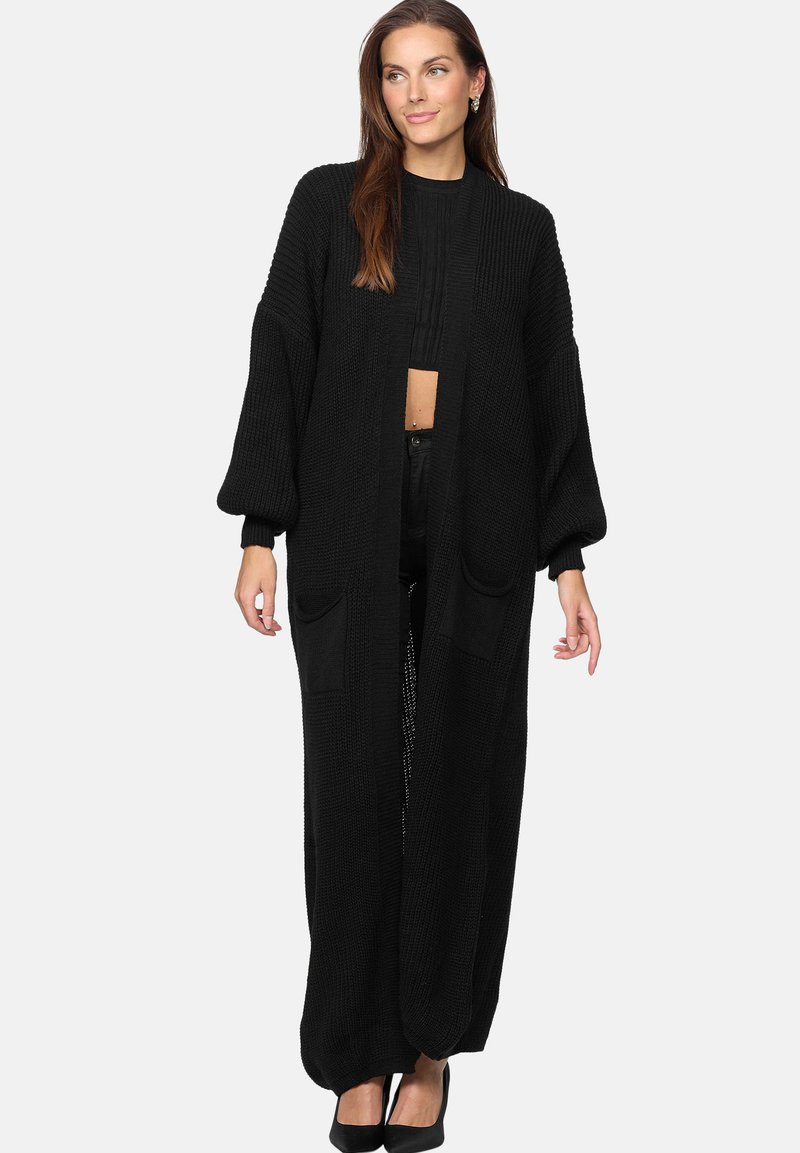 Svart stickad cardigan med långa, lösa ärmar och sidofickor. Texturerat material, öppen framsidan och golvlång design.