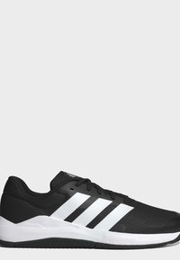 Baskets de sport noir et blanc avec trois bandes blanches sur le côté, lacets noirs et semelle texturée noire et blanche.
