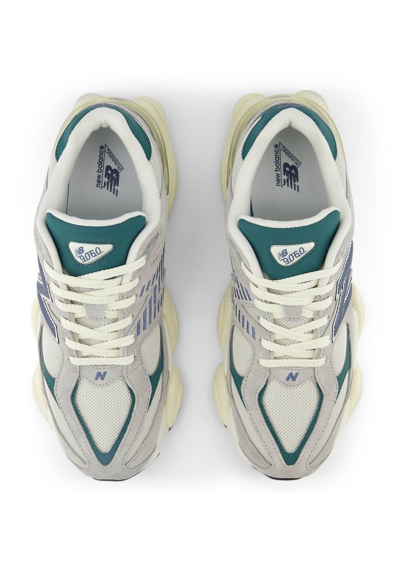 Gray and teal sneakers with a mesh and suede upper, thick midsole, and white laces. Features a blue logo and striped pattern on the sides.
