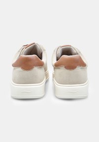 Beige nubukist ülemise osaga ja pruuni nahast kanna aktsentidega sneaksid. Valged kummist tallad ja sile, tekstuuriga viimistlus.