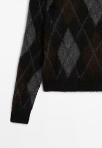 Maglione argyle in nero e grigio, realizzato in tessuto morbido e texture, con scollo rotondo e maniche lunghe.