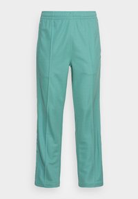 Pantalons de sport teal en tissu doux, avec une taille élastique, une coupe droite et des coutures latérales subtile pour un détail de design supplémentaire.