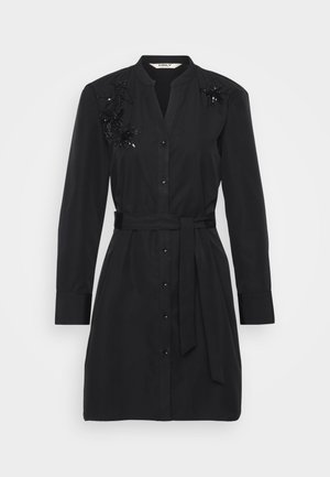 Vestido negro de algodón con cinturón en la cintura, botón en la parte delantera y detalles decorativos de lentejuelas florales en los hombros.