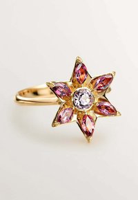 Anillo de oro con un diseño en forma de estrella que presenta una gema central clara rodeada por seis gemas cortadas en marquesa de color rosa.
