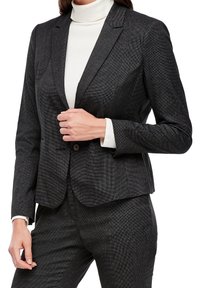 Szary, strukturalny żakiet o teksturowanej powierzchni, zapinany na pojedynczy guzik, z klapami, noszony na białym golfie.